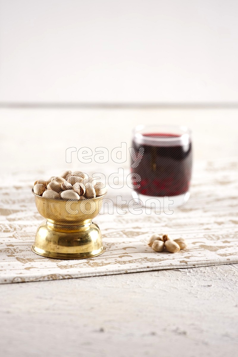 Nuts in a metal bowl with hibiscus in a light setup