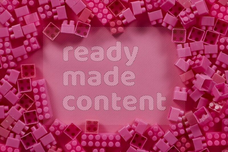 مكعبات بناء بلاستيكية وردية على خلفية وردية (ألعاب للأطفال)