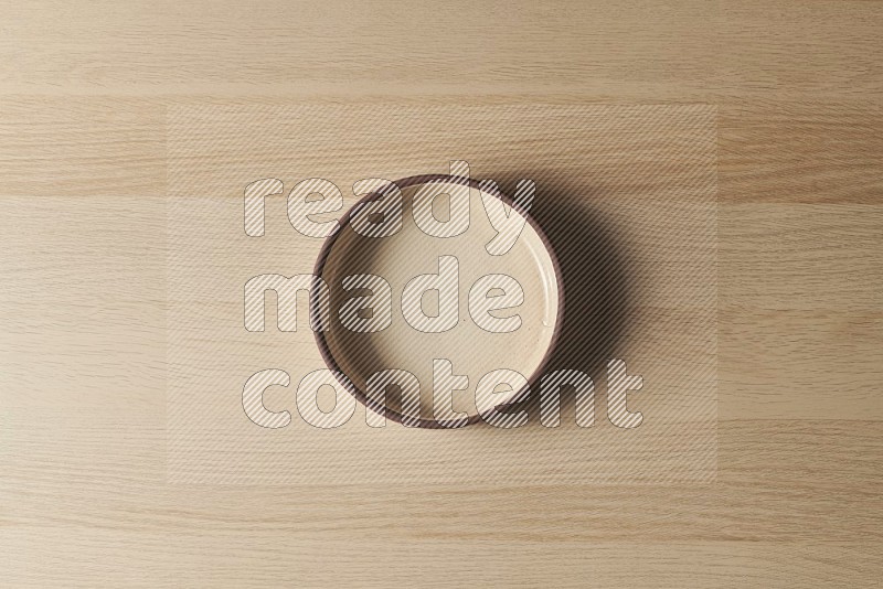 Top View Shot Of A Beige Pottery Oven Plate on Oak Wooden Flooring
