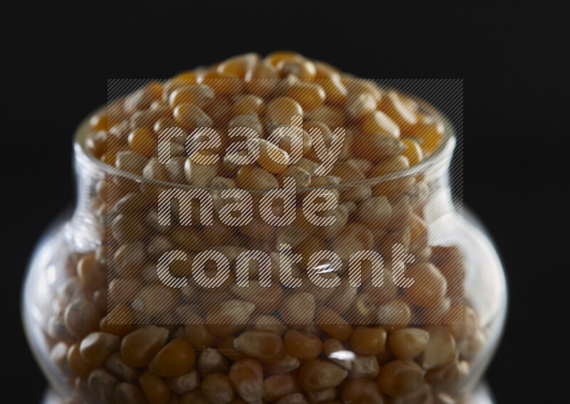 Pop corn in a glass jar on black background