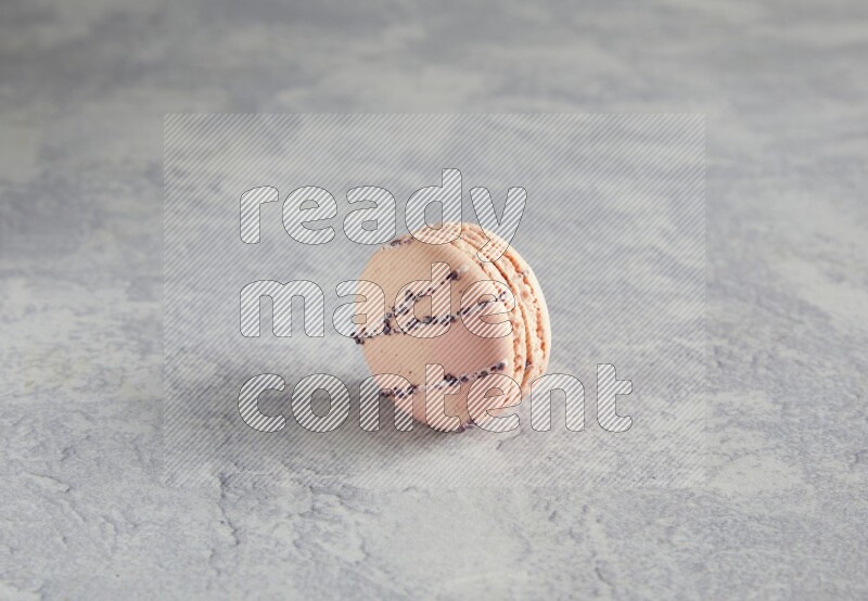 45º Shot of pink orange blossom macaron on white  marble background
