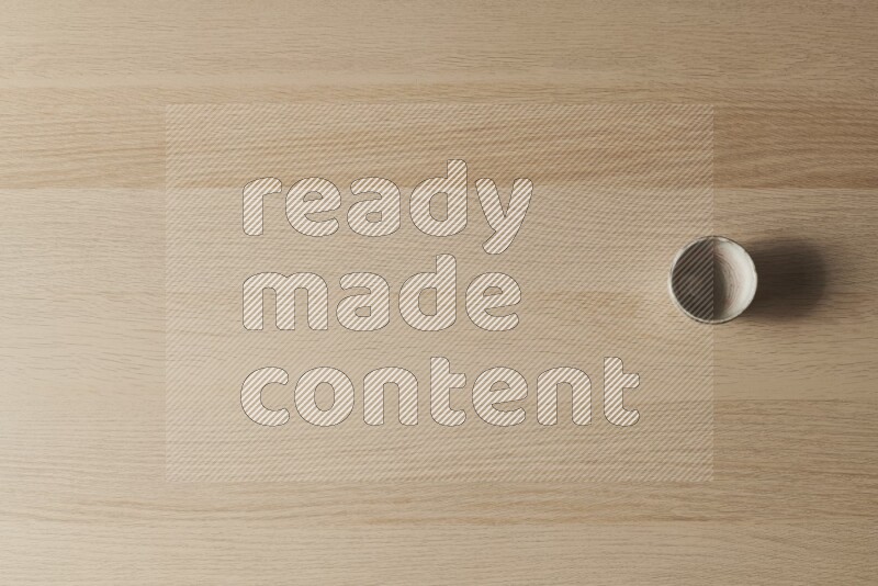 A pottery cup on light wooden background
