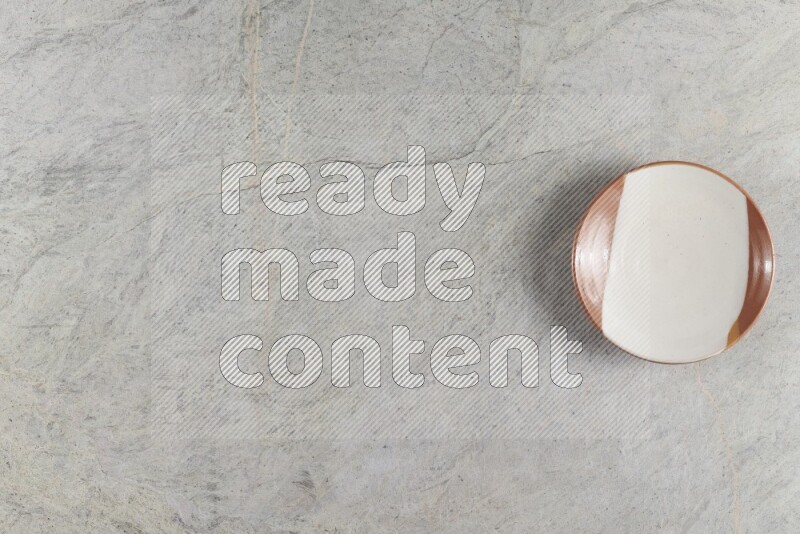 صحن فخاري متعدد الألوان على خلفية من الرخام الرمادي