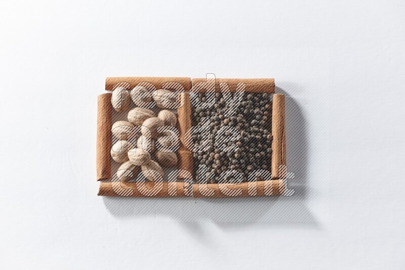 2 squares of cinnamon sticks full of black pepper and nutmegs on white flooring
