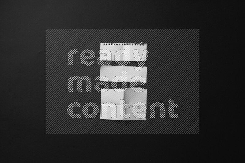 Ripped notebook sheet on black background