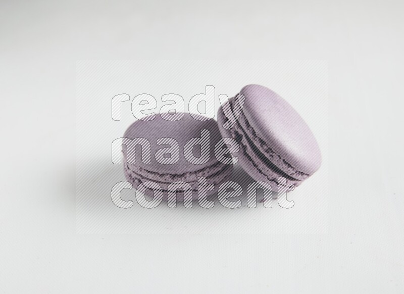 45º Shot of two Purple Blueberry macarons on white background