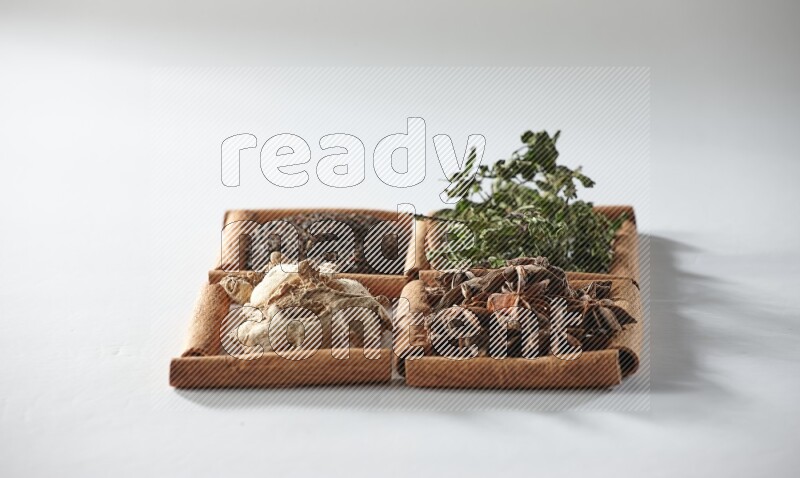 4 squares of cinnamon sticks full of tea, mint, star anise and ginger on white flooring