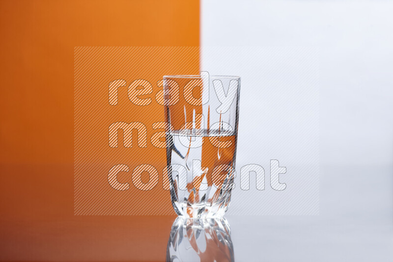 The image features a clear glassware filled with water, set against white and orange background