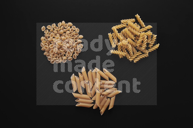 Different pasta types in bunches on black background