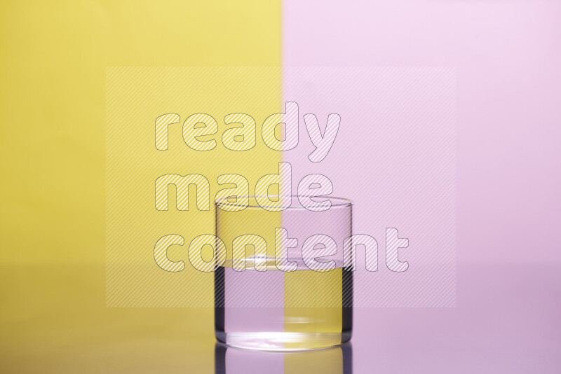 The image features a clear glassware filled with water, set against yellow and rose background