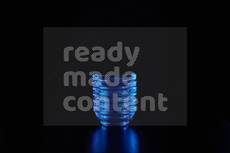 Glassware with rim light in blue against black background