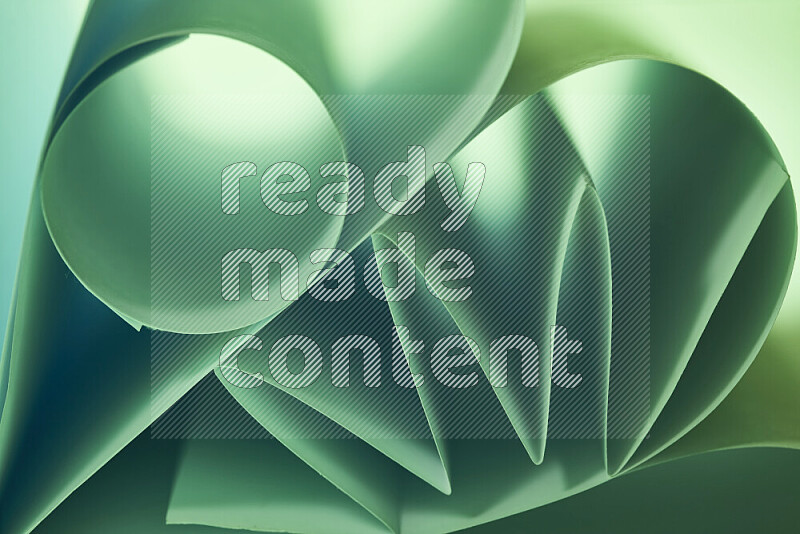 An artistic display of paper folds creating a harmonious blend of geometric shapes, highlighted by soft lighting in green tones