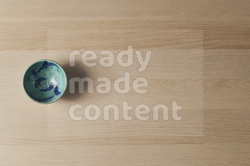 A decorative pottery bowl on light wooden background
