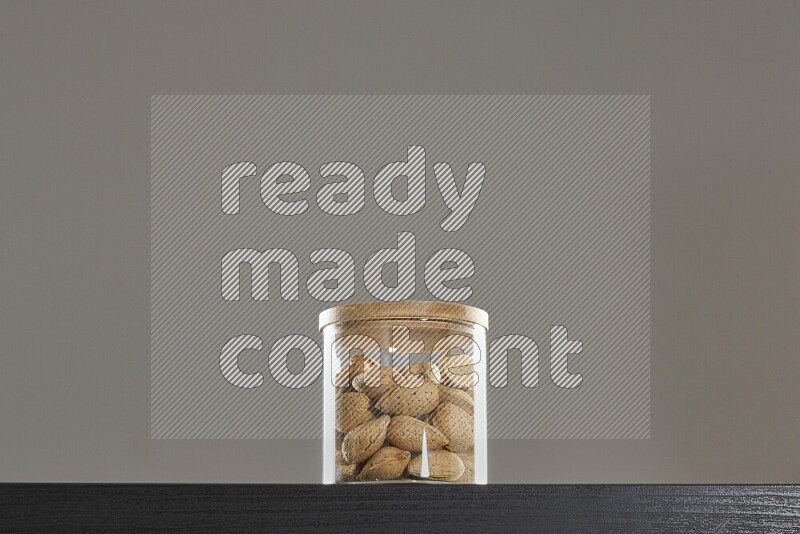 Almonds in a glass jar on black background
