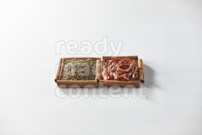 2 squares of cinnamon sticks full of dried red chilis and cumin on white flooring