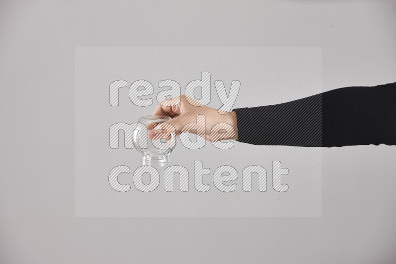 A woman in black abaya holding different glassware in different positions