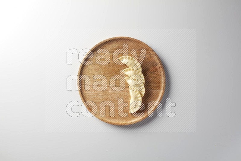 Four Sambosas on a wooden round plate on a white background