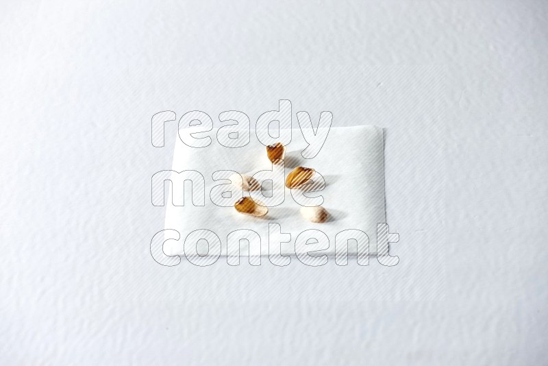 Pistachio peels on a piece of paper on a white background in different angles