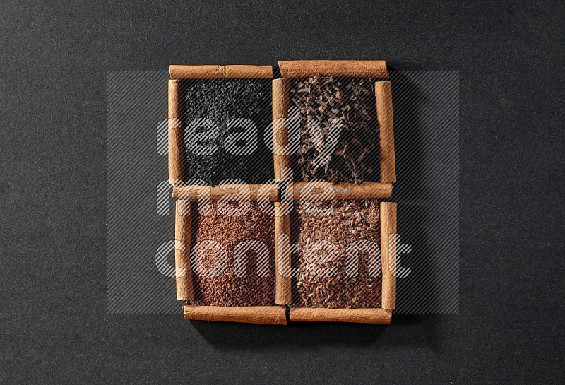 4 squares of cinnamon sticks full of black seeds, garden cress, flaxseeds and cloves on black flooring