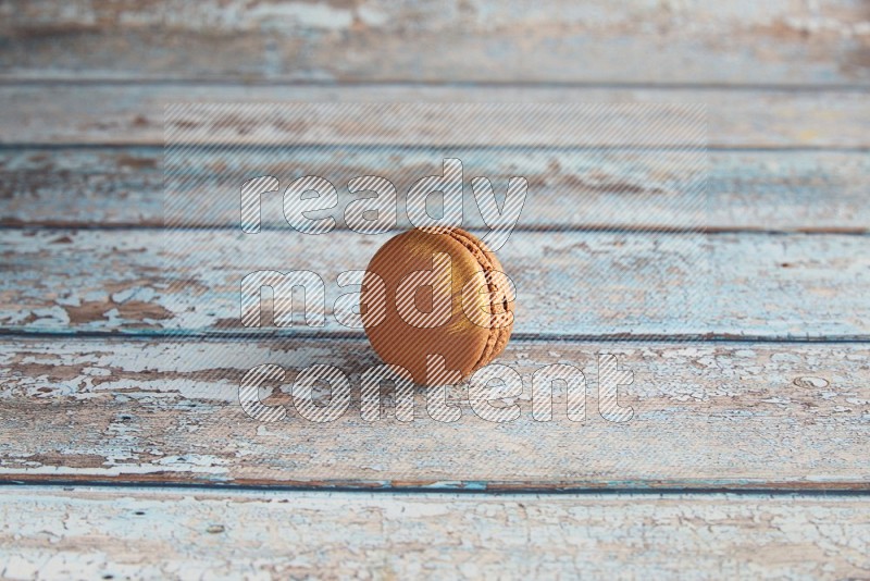 45º Shot of Brown Coffee macaron on light blue wooden background