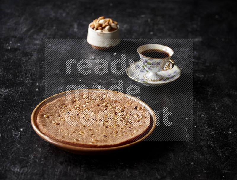 Basbousa with nuts and tea in a dark setup