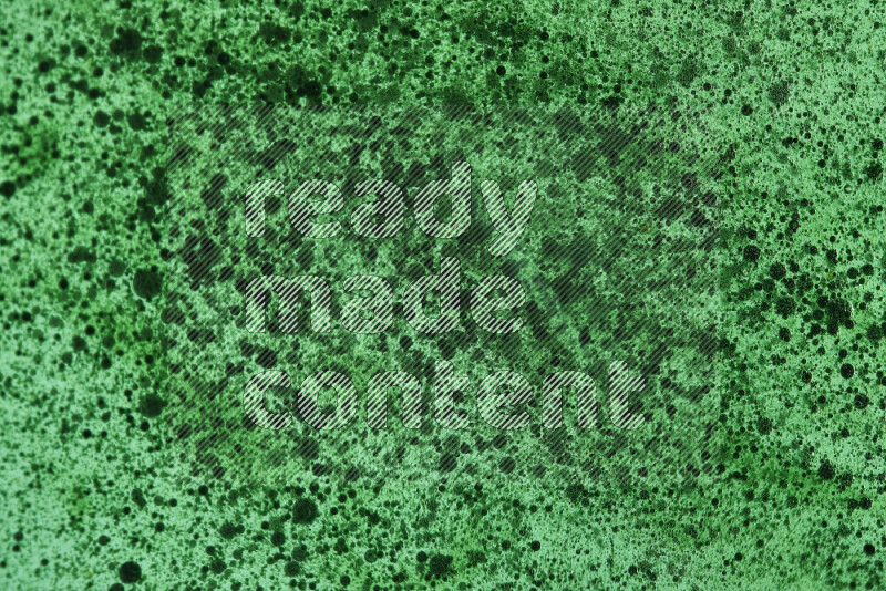 Close-ups of abstract green watercolor drops on oil Surface on green background