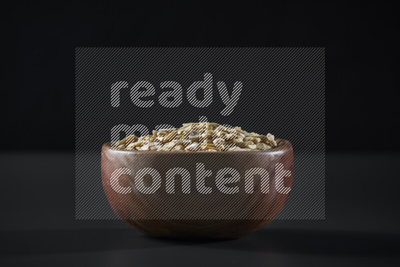 Crushed beans in a wooden bowl on grey background