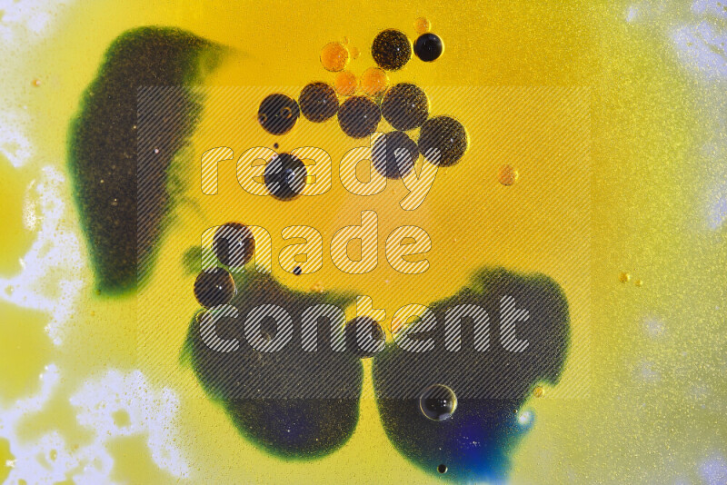 لقطات مقربة لقطرات ألوان مائية صفراء وزرقاء وخضراء على سطح الزيت على خلفية بيضاء