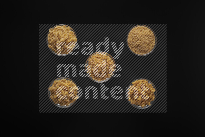 أنواع مختلفة من المعكرونة في أوعية زجاجية علي خلفية سوداء