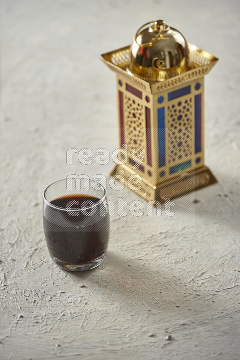 A golden lantern with different drinks, dates, nuts, prayer beads and quran on textured white background