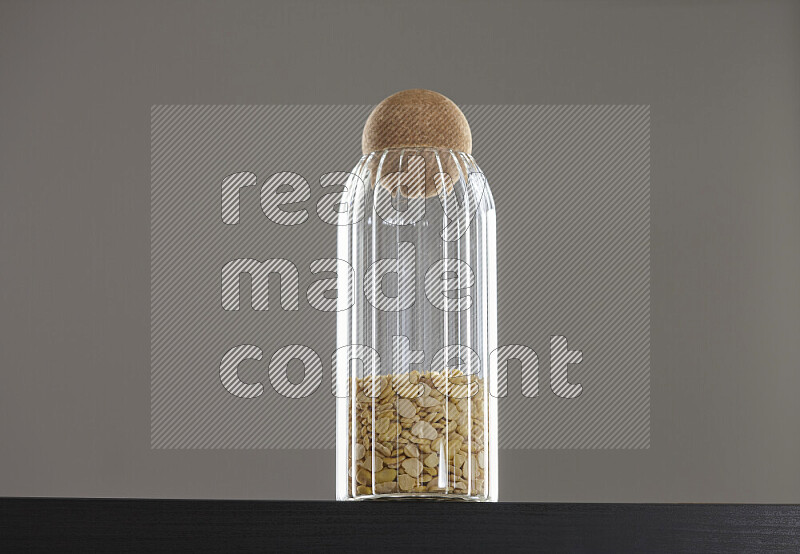 Crushed beans in a glass jar on black background