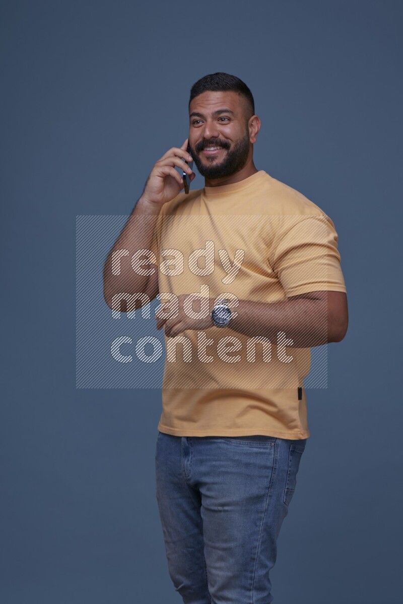 A man Calling on Blue Background wearing Orange T-shirt
