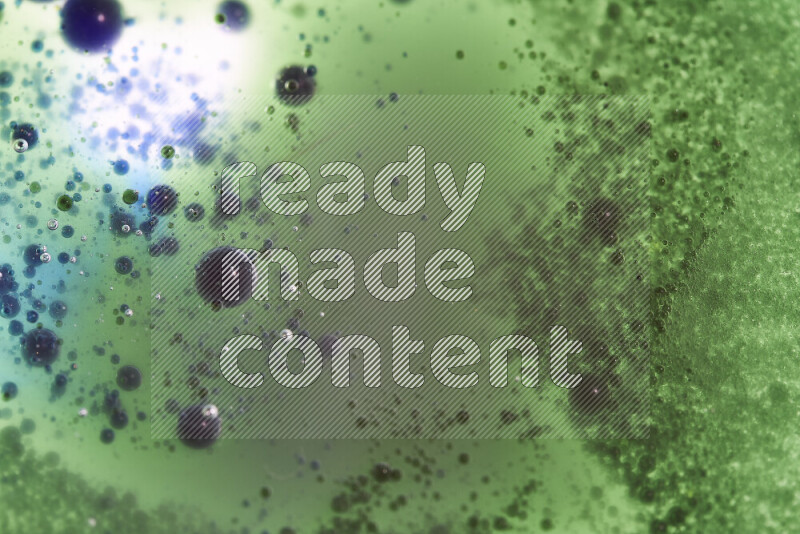 لقطات مقربة لقطرات ألوان مائية خضراء وزرقاء على سطح الزيت على خلفية بيضاء