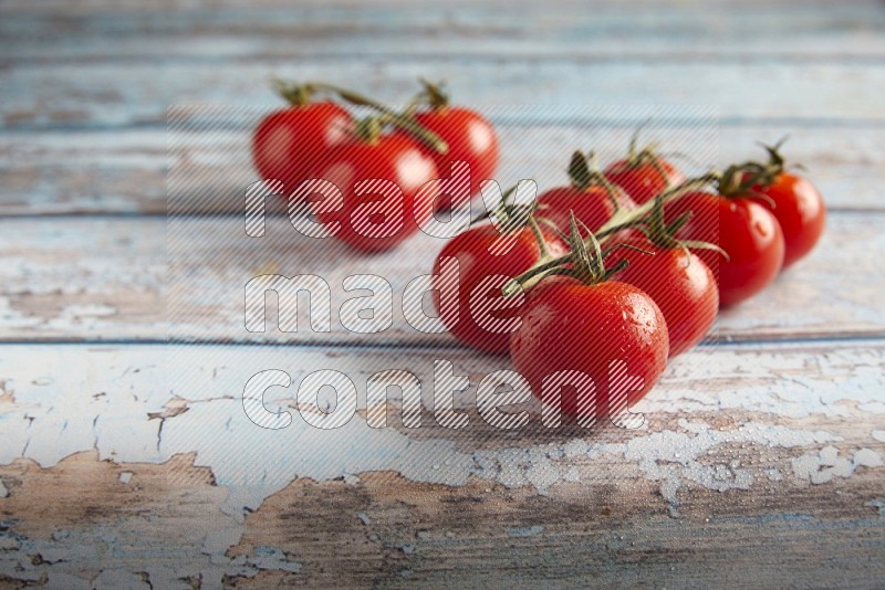 Red cherry tomato vein on a textured blue wooden background 45 degree