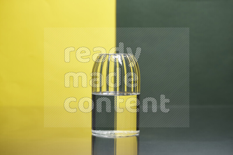 The image features a clear glassware filled with water, set against yellow and dark green background