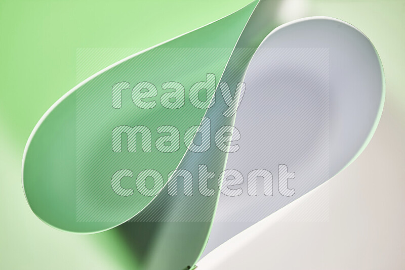 An abstract art of paper folded into smooth curves in white and green gradients