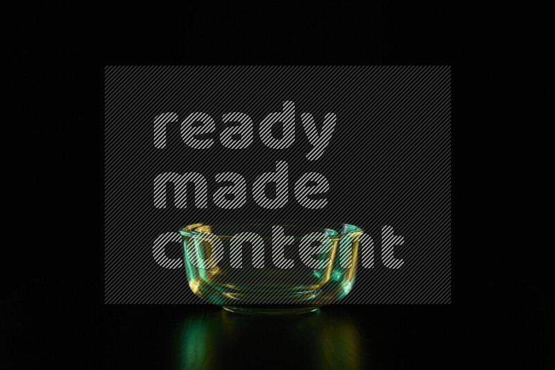 Glassware with rim light in green and yellow against black background