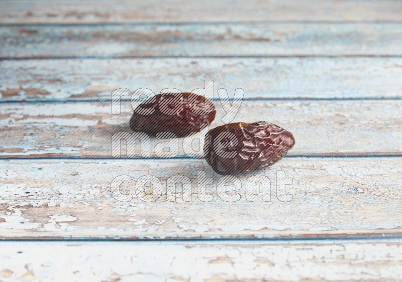 two madjoul dates on a light blue wooden background