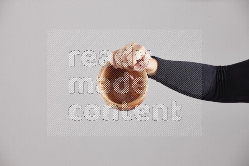A woman in black abaya holding different wooden essentials in different positions