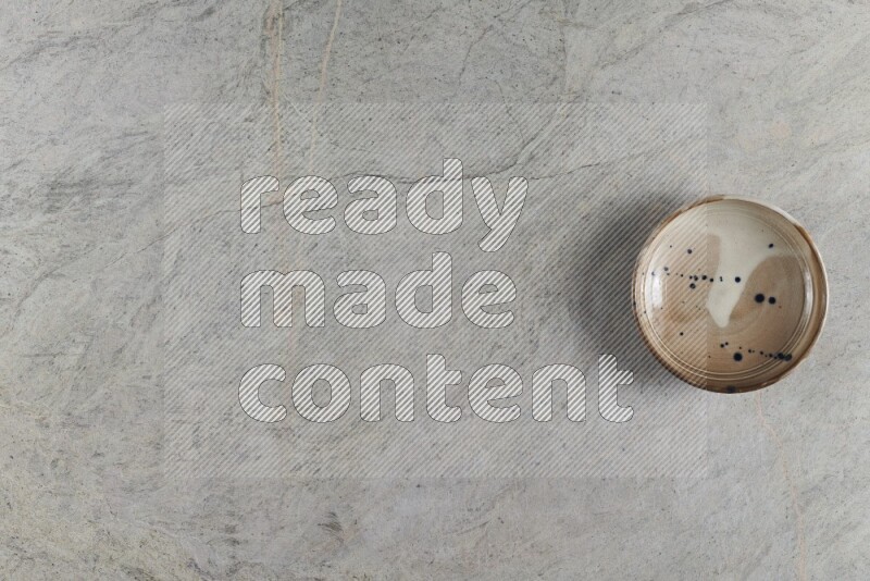 وعاء فخاري متعدد الألوان على خلفية من الرخام الرمادي