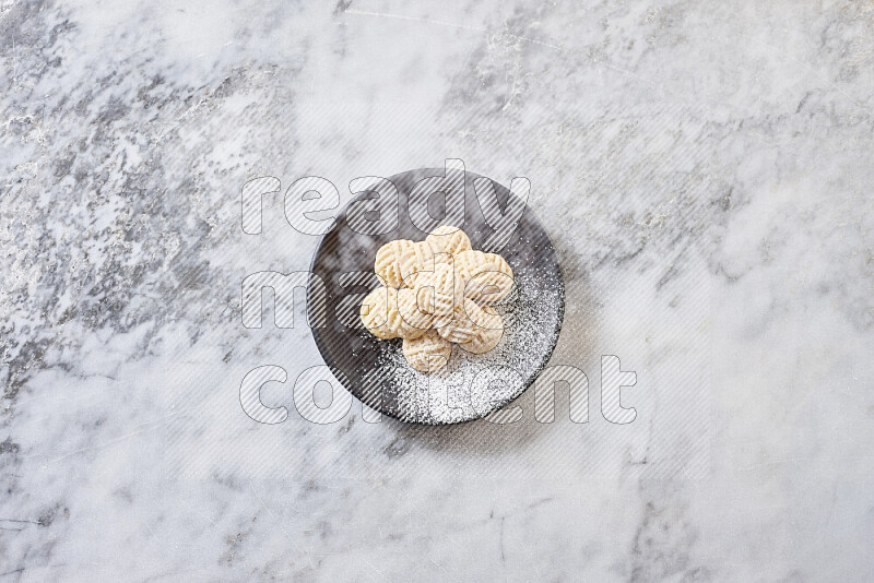 Kahk in black pottery plate on grey marble background