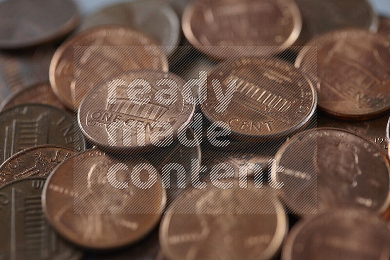 A close-up of scattered United States one cent coins on grey background
