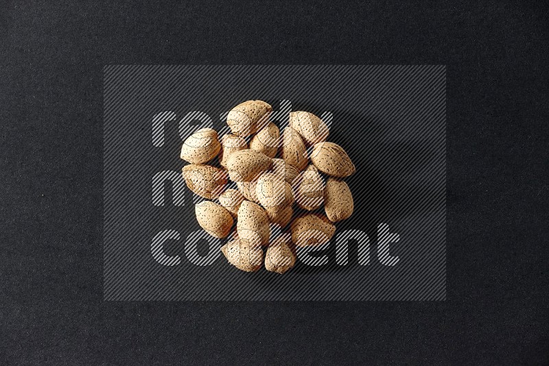 A bunch of almonds on a black background in different angles