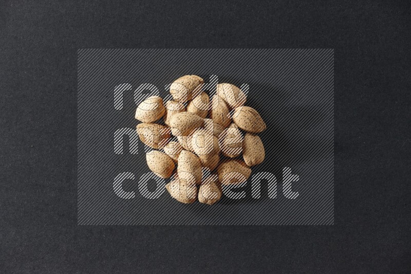 A bunch of almonds on a black background in different angles