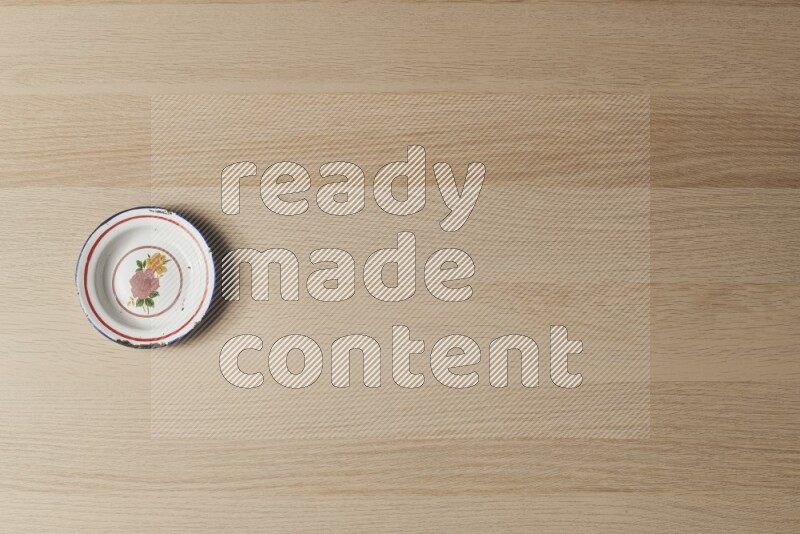 A vintage metal plate on light wooden background