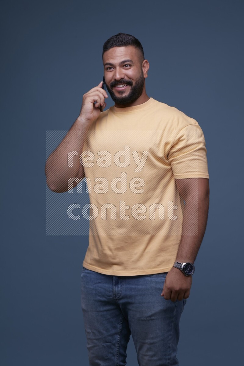 A man Calling on Blue Background wearing Orange T-shirt