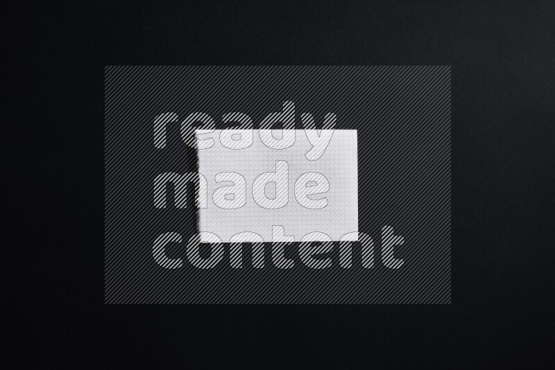 Folded notebook sheet on black background