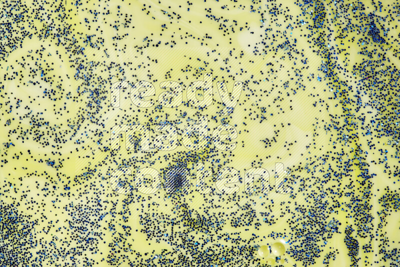 لقطة مقربة لبريق أزرق متلألئ منتشر على خلفية من اللون الأصفر في حركات دائرية