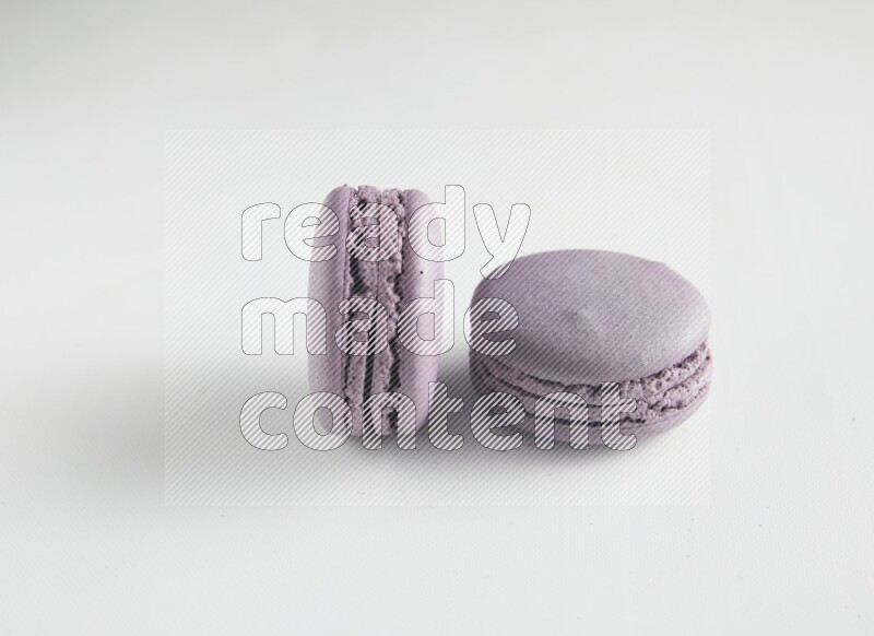 45º Shot of two Purple Blueberry macarons on white background