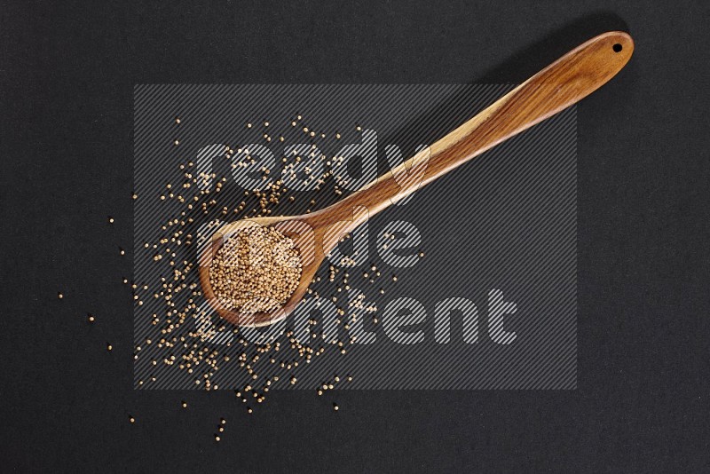 A wooden ladle full of mustard seeds on a black flooring in different angles